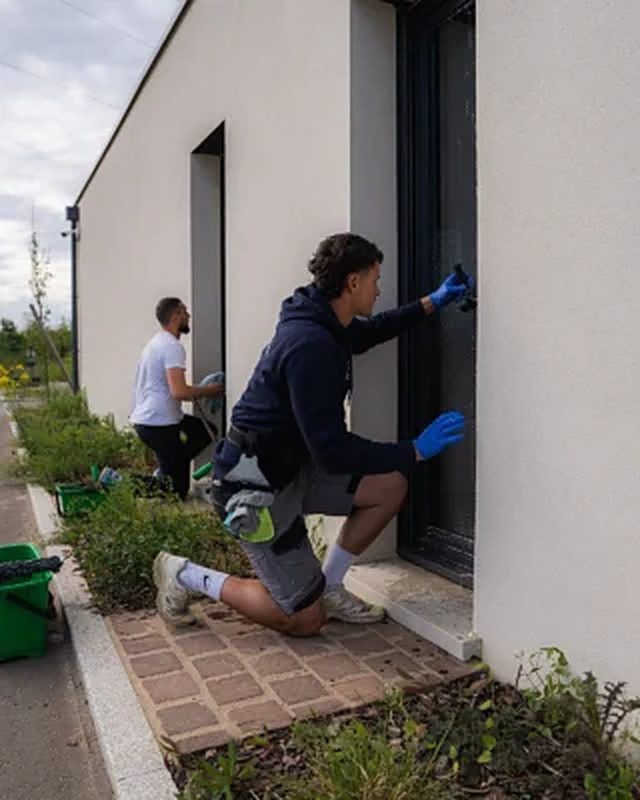 Deux techniciens Azuraa nettoyant les vitres d'une maison individuelle